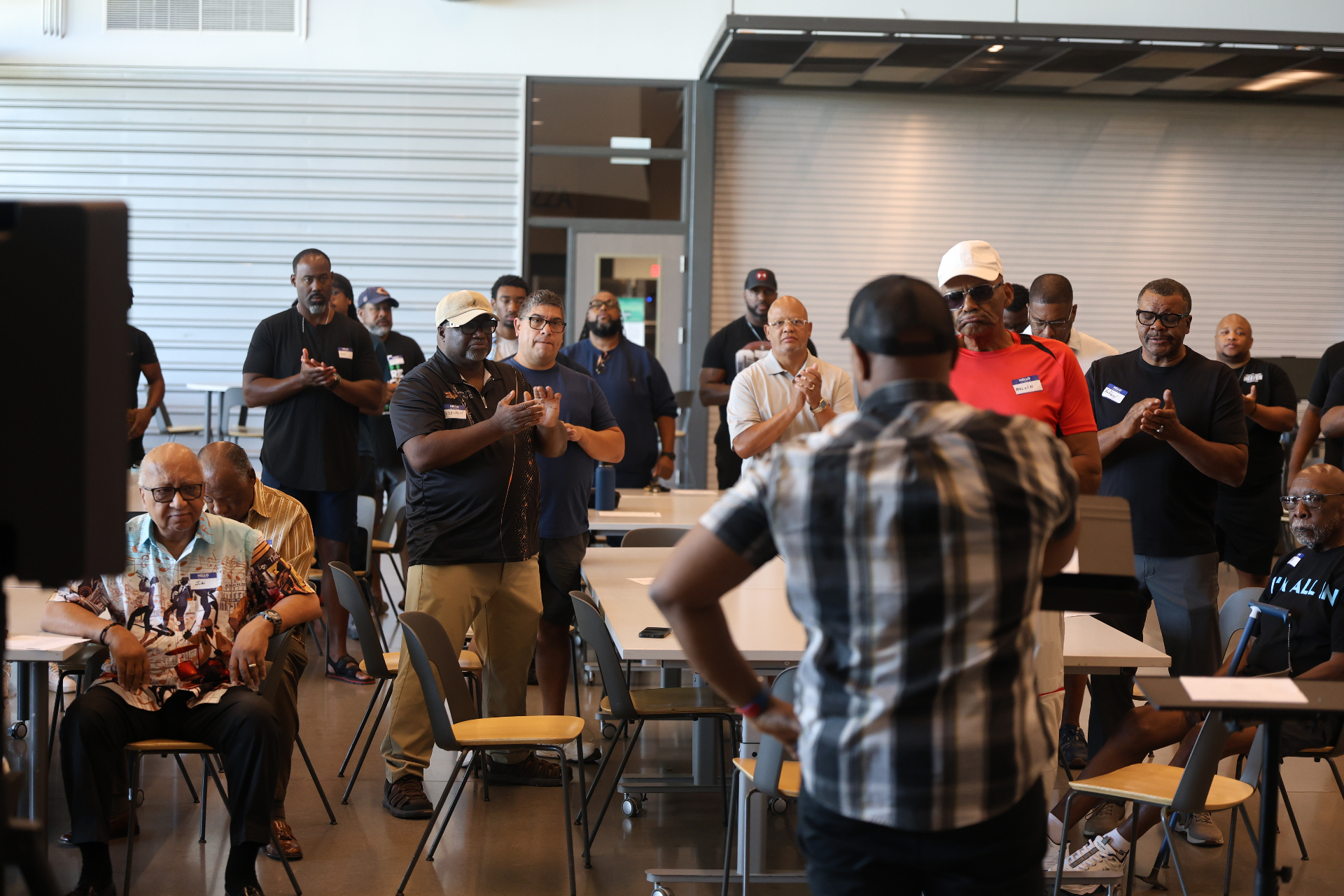 Men standing and applauding during a gathering