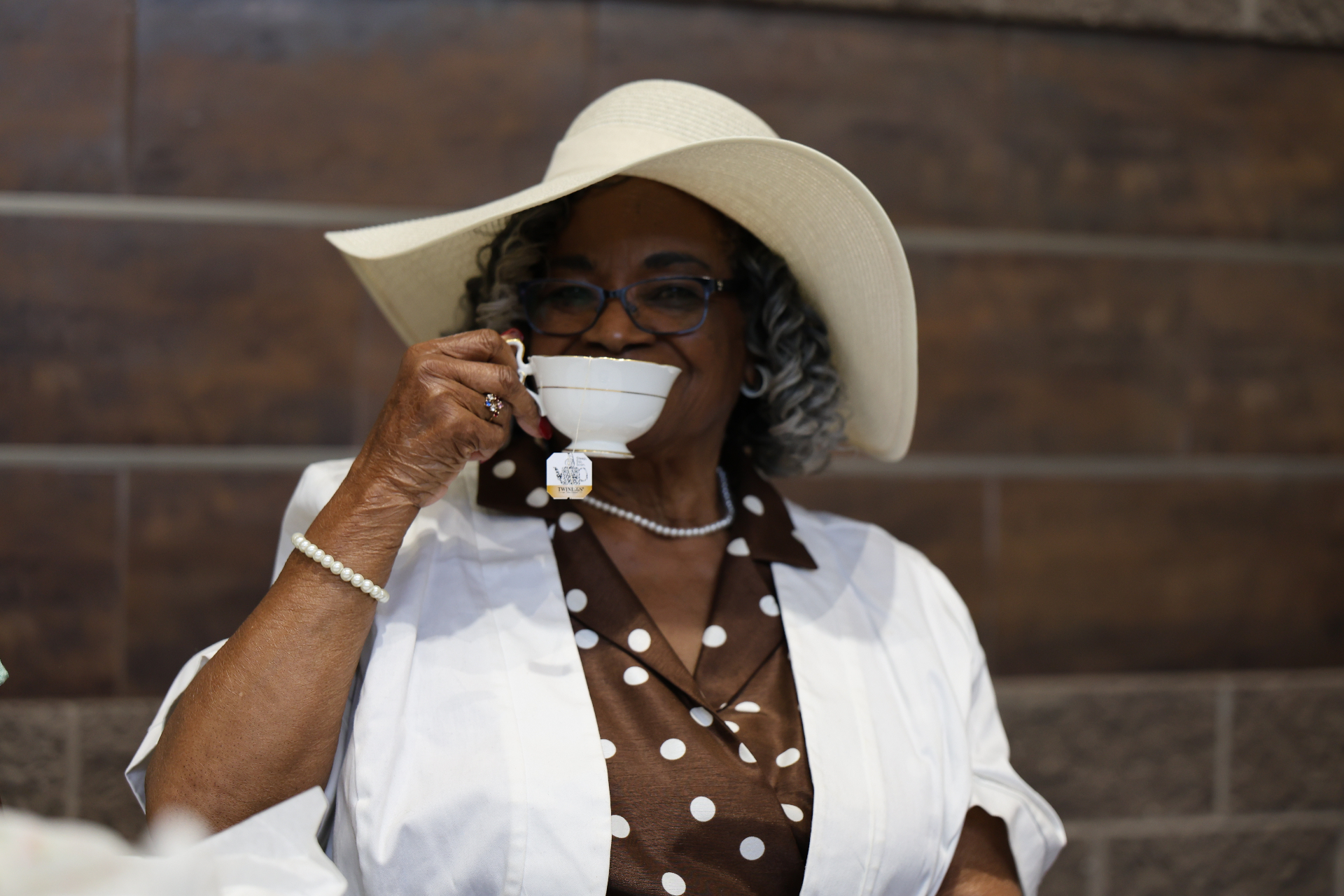 Woman in a sunhat sipping tea